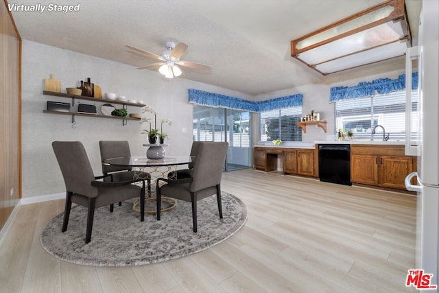 dining area featuring a healthy amount of sunlight, a textured ceiling, and light hardwood / wood-style flooring