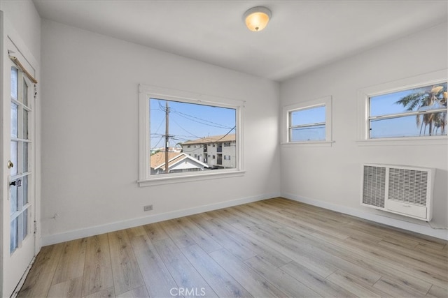 empty room with heating unit and light wood-type flooring