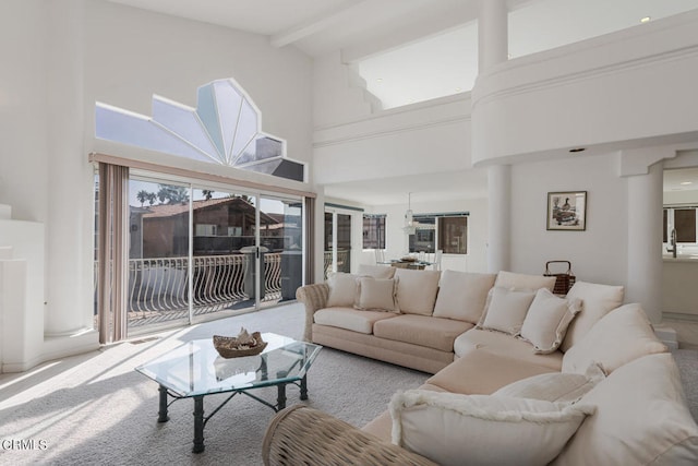 carpeted living room with beamed ceiling, high vaulted ceiling, and sink