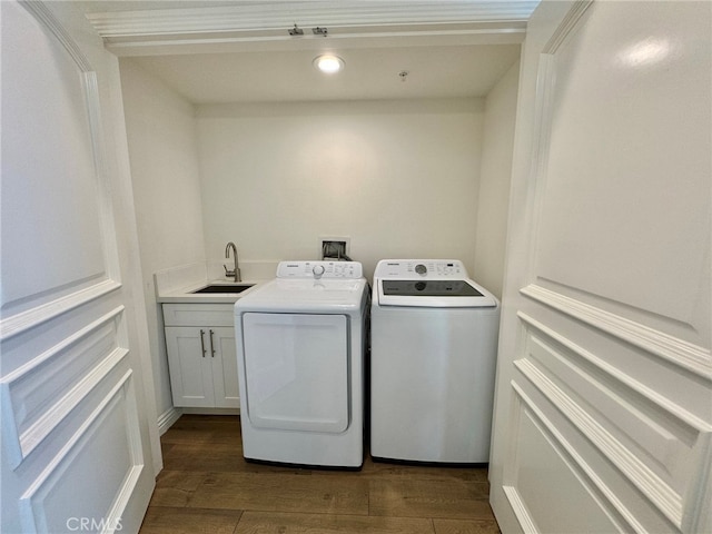 clothes washing area featuring cabinets, dark hardwood / wood-style floors, sink, and washer and dryer