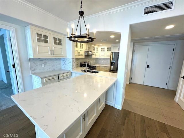 kitchen featuring pendant lighting, light stone counters, stainless steel appliances, dark hardwood / wood-style floors, and white cabinetry