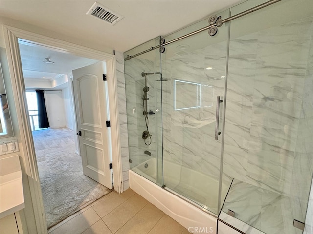 bathroom featuring tile patterned flooring and shower / bath combination with glass door