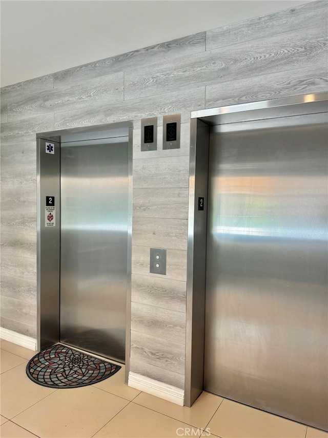 details featuring wooden walls, tile patterned flooring, and elevator