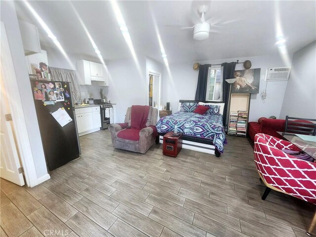 bedroom featuring ceiling fan, stainless steel fridge, and an AC wall unit