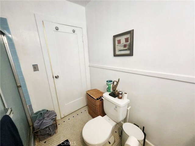 bathroom featuring toilet, tile patterned floors, and walk in shower