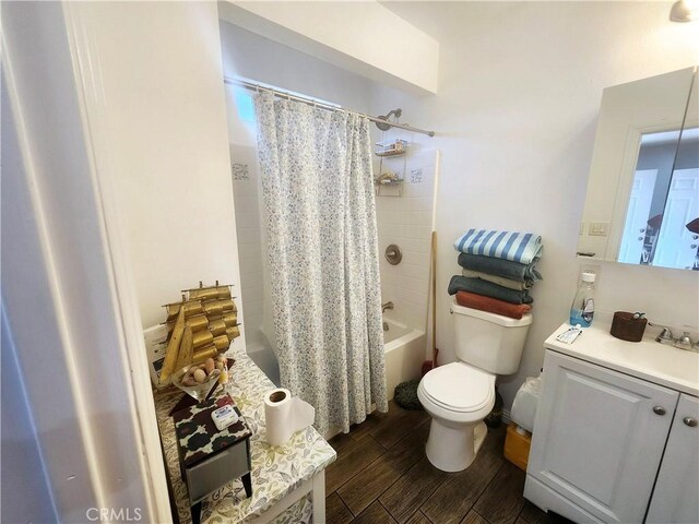 full bathroom featuring hardwood / wood-style floors, vanity, shower / tub combo, and toilet