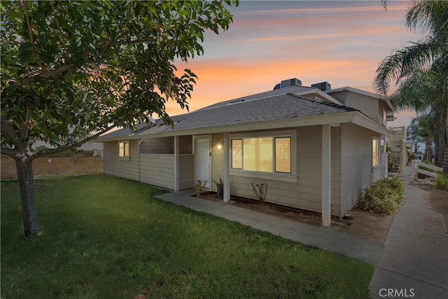 back house at dusk with a lawn