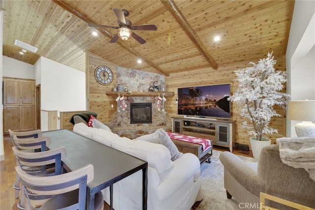 living room featuring beamed ceiling, ceiling fan, wood ceiling, and wooden walls