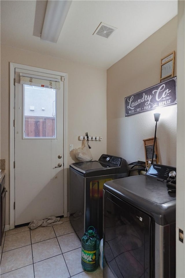 washroom with washing machine and dryer and light tile patterned floors