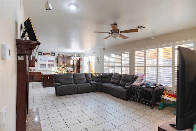 tiled living room featuring ceiling fan with notable chandelier