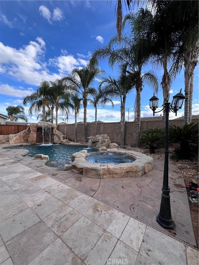 view of swimming pool with pool water feature and an in ground hot tub