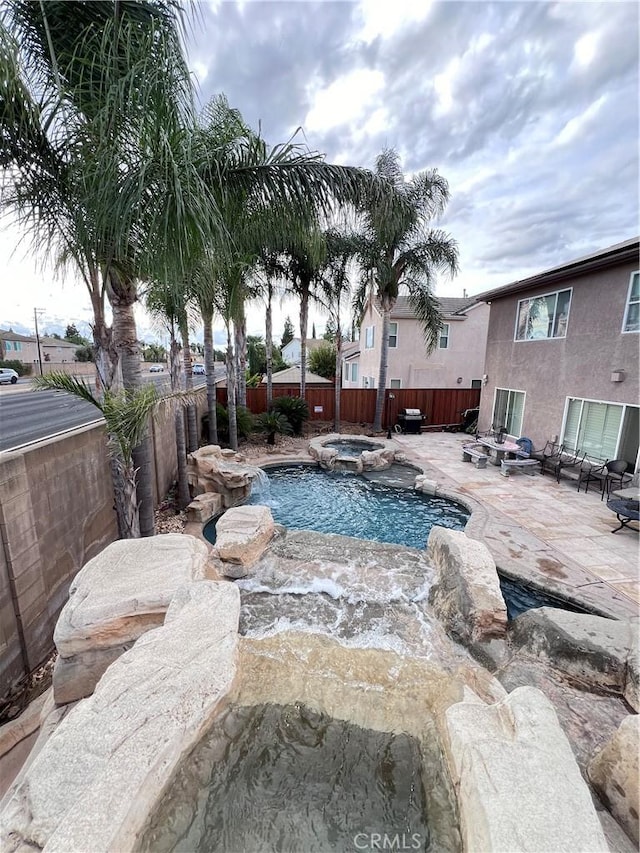 view of pool with a patio area and an in ground hot tub