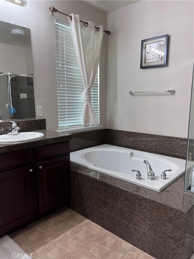 bathroom featuring tile patterned floors, tiled tub, and vanity