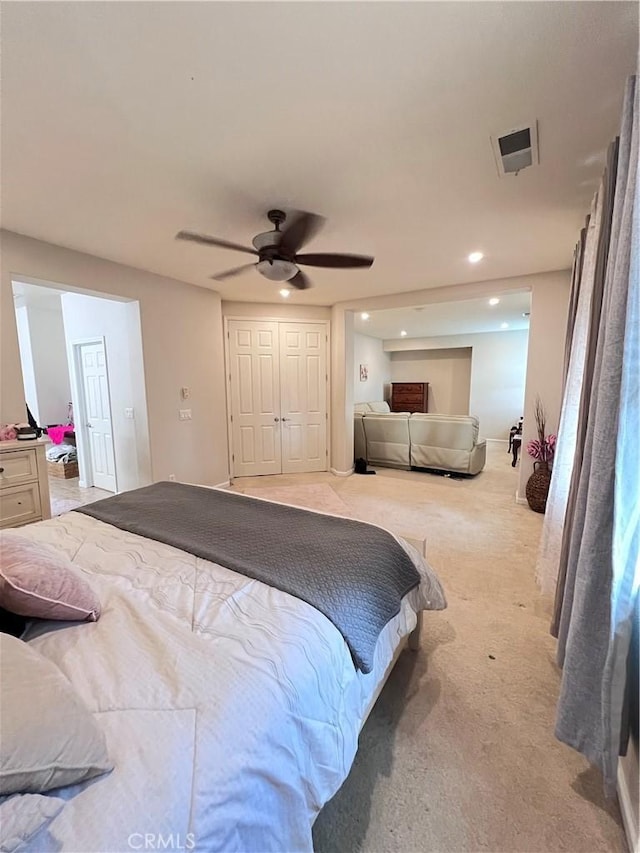 carpeted bedroom featuring ceiling fan and a closet