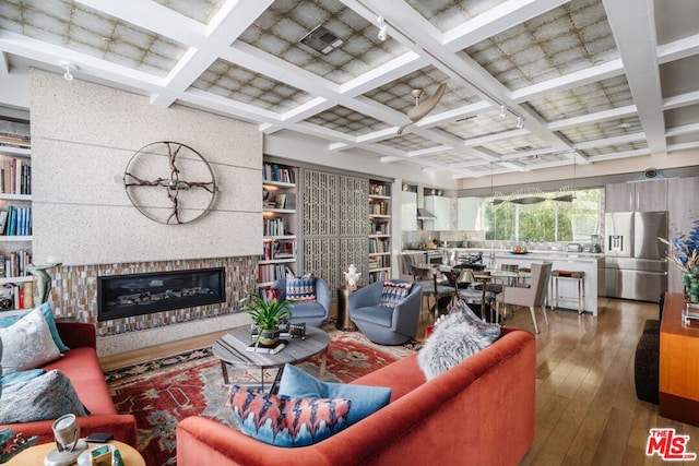 living room with coffered ceiling, hardwood / wood-style flooring, and beam ceiling