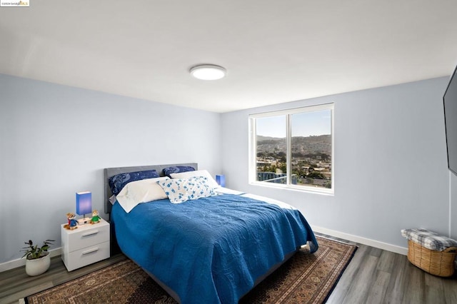 bedroom with dark hardwood / wood-style flooring