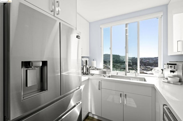 kitchen with white cabinetry, stainless steel appliances, and dark wood-type flooring