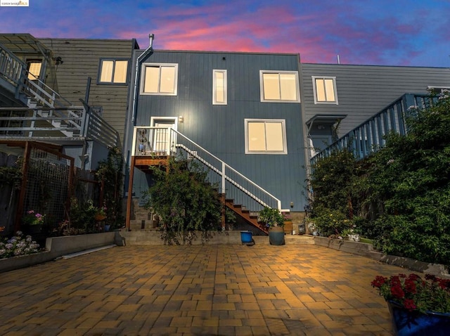 back house at dusk featuring a patio