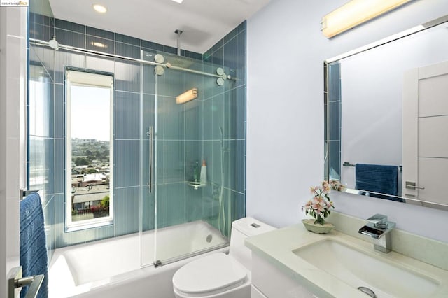 full bathroom with vanity, toilet, and enclosed tub / shower combo