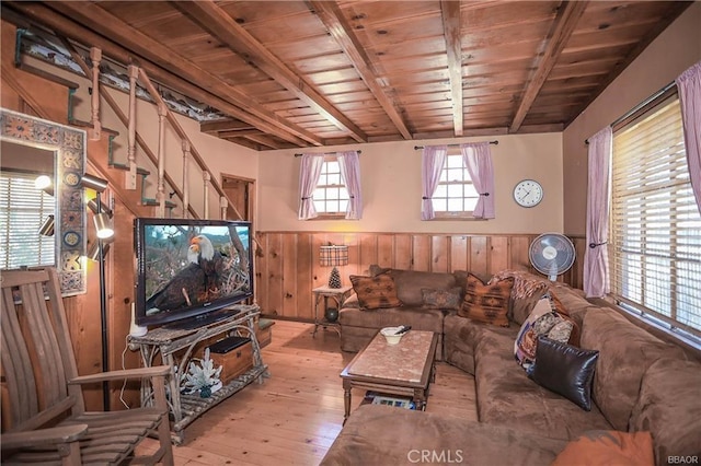 living room featuring beam ceiling, wooden walls, light hardwood / wood-style flooring, and wood ceiling