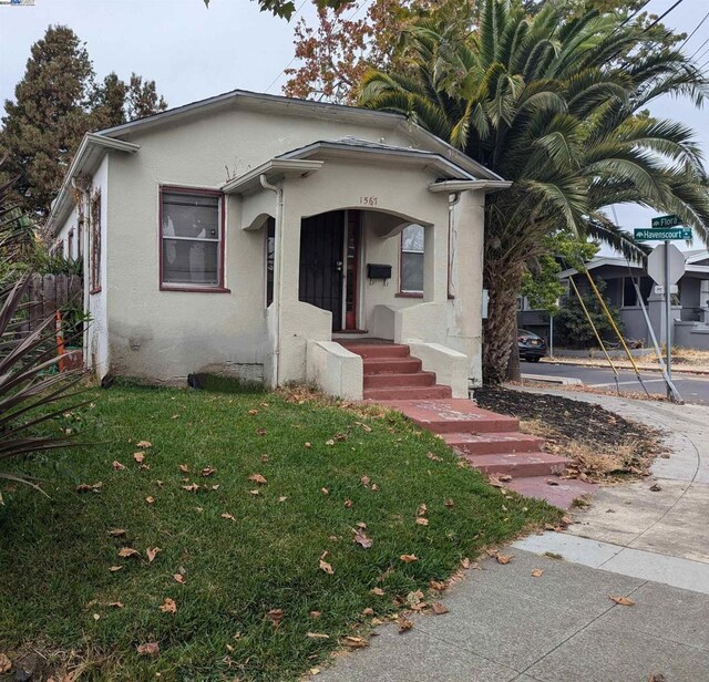 bungalow-style house featuring a front lawn