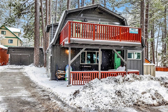 snow covered rear of property with a wooden deck