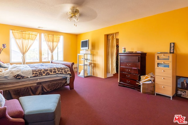 carpeted bedroom featuring a textured ceiling and ceiling fan