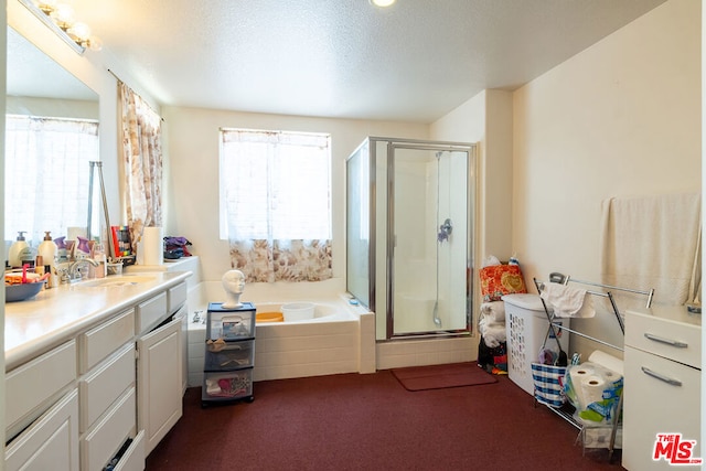 bathroom with vanity, a textured ceiling, shower with separate bathtub, and plenty of natural light