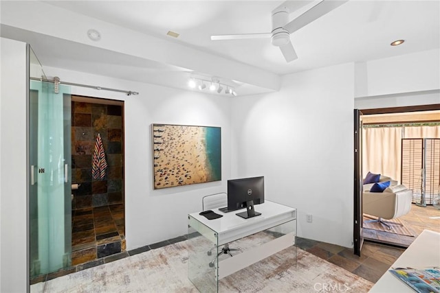 office area with ceiling fan and a barn door