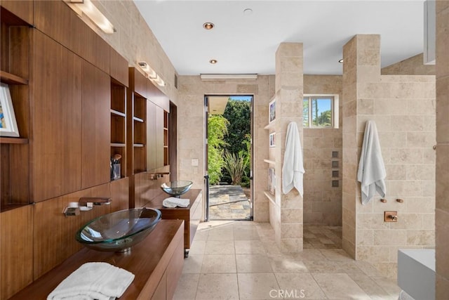 bathroom featuring vanity, tile patterned flooring, shower with separate bathtub, and tile walls