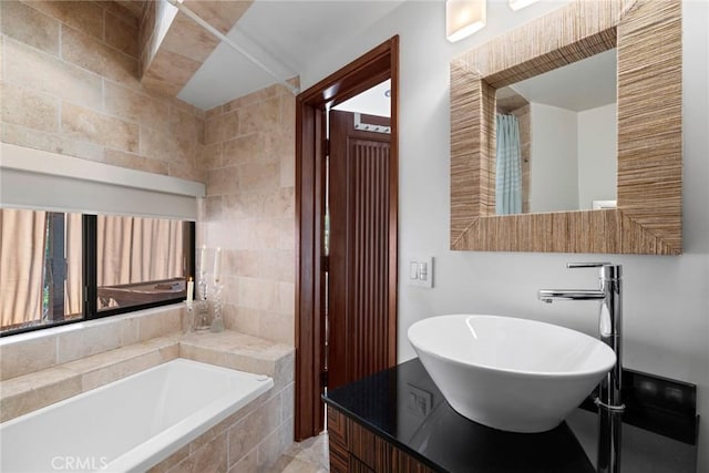 bathroom featuring tiled tub and sink