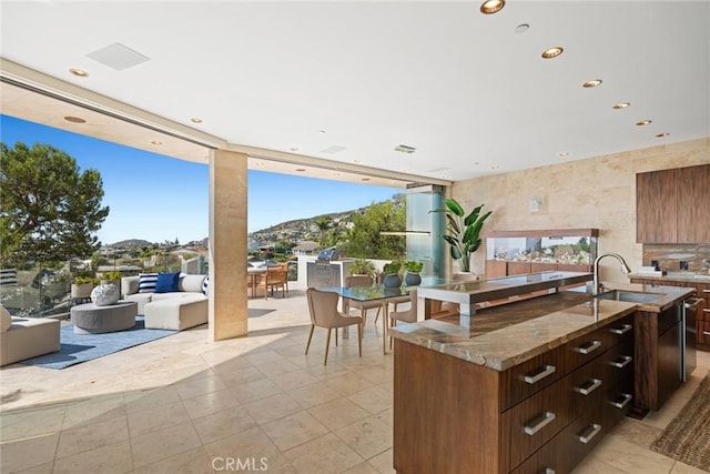 kitchen featuring a mountain view, sink, dark stone countertops, and a wall of windows