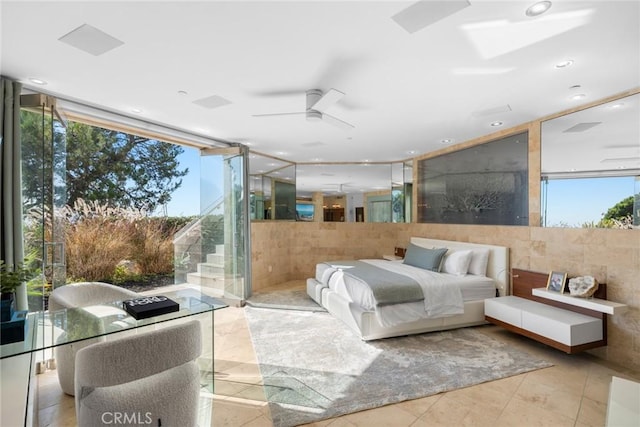 bedroom featuring tile walls and a wall of windows