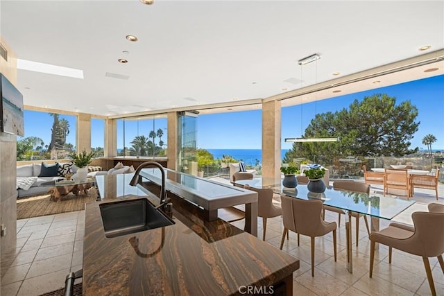 view of patio / terrace featuring a water view, sink, and an outdoor hangout area