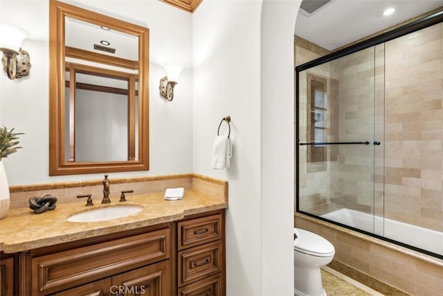 full bathroom featuring vanity, enclosed tub / shower combo, and toilet