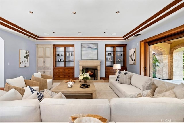 living room with light hardwood / wood-style flooring, crown molding, and a tray ceiling