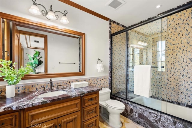 full bathroom with vanity, ornamental molding, shower / bath combination with glass door, and toilet