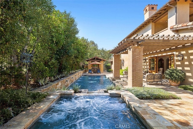 view of pool with a gazebo, pool water feature, a pergola, a patio area, and an in ground hot tub