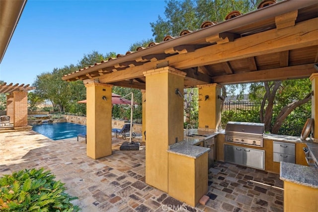 view of patio / terrace featuring a gazebo, an outdoor kitchen, area for grilling, a fenced in pool, and sink