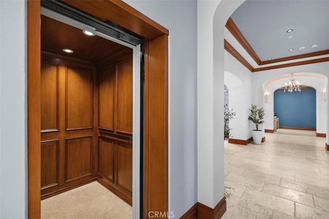 hallway with ornamental molding, a notable chandelier, and elevator