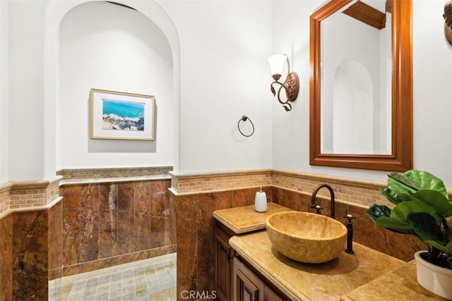 bathroom with vanity and tile walls