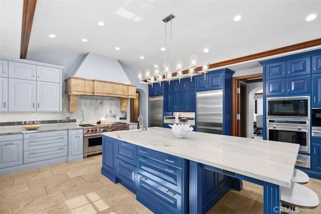 kitchen with a spacious island, backsplash, blue cabinets, built in appliances, and light stone counters