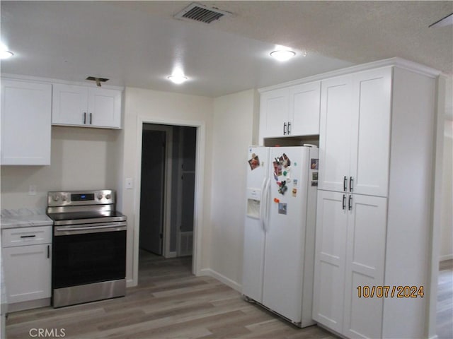 kitchen with stainless steel range with electric stovetop, white refrigerator with ice dispenser, light hardwood / wood-style floors, light stone counters, and white cabinetry