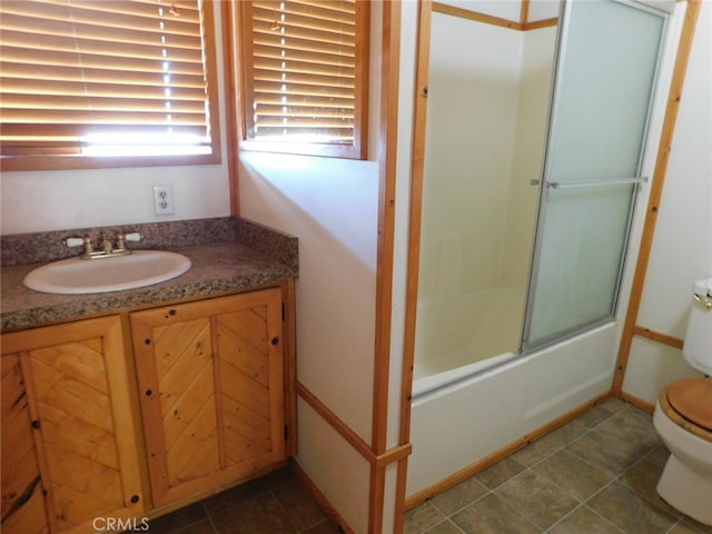 full bathroom with enclosed tub / shower combo, tile patterned floors, vanity, and toilet