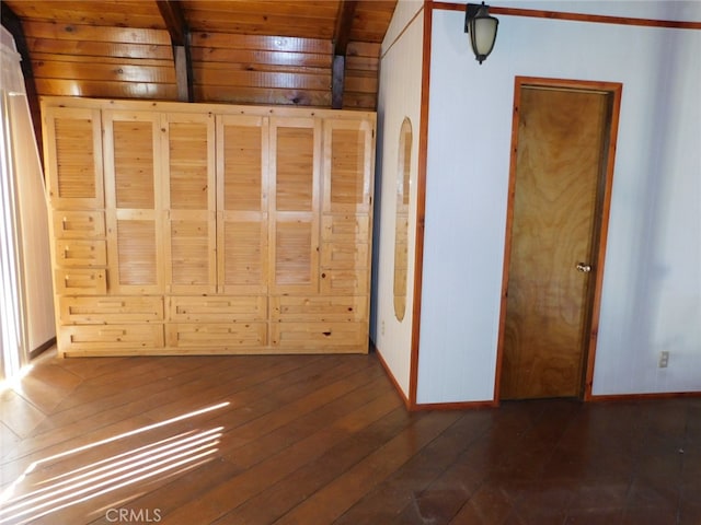 unfurnished bedroom featuring wood walls, wood ceiling, beam ceiling, and dark hardwood / wood-style flooring