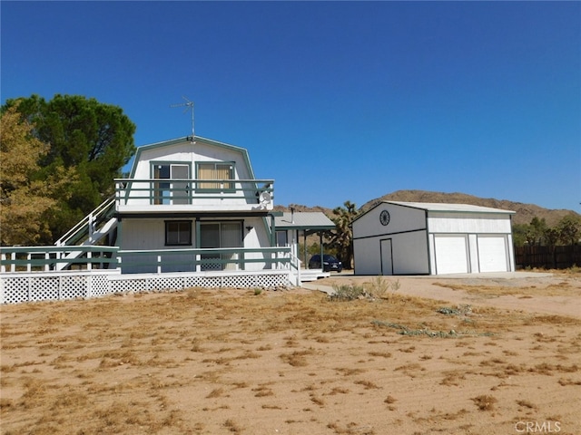 back of property featuring a garage, an outbuilding, and a balcony