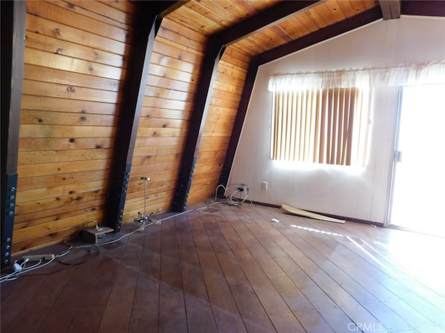 empty room with vaulted ceiling with beams, plenty of natural light, dark hardwood / wood-style flooring, and wooden ceiling