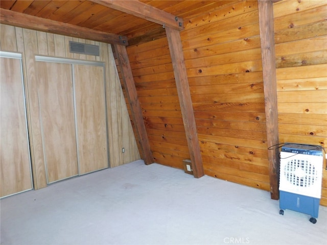 unfurnished bedroom featuring beamed ceiling, wooden walls, light carpet, and wood ceiling