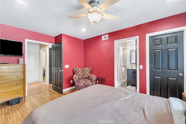 bedroom featuring hardwood / wood-style floors, ensuite bathroom, and ceiling fan