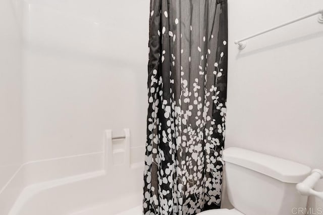 bathroom featuring a shower with shower curtain and toilet